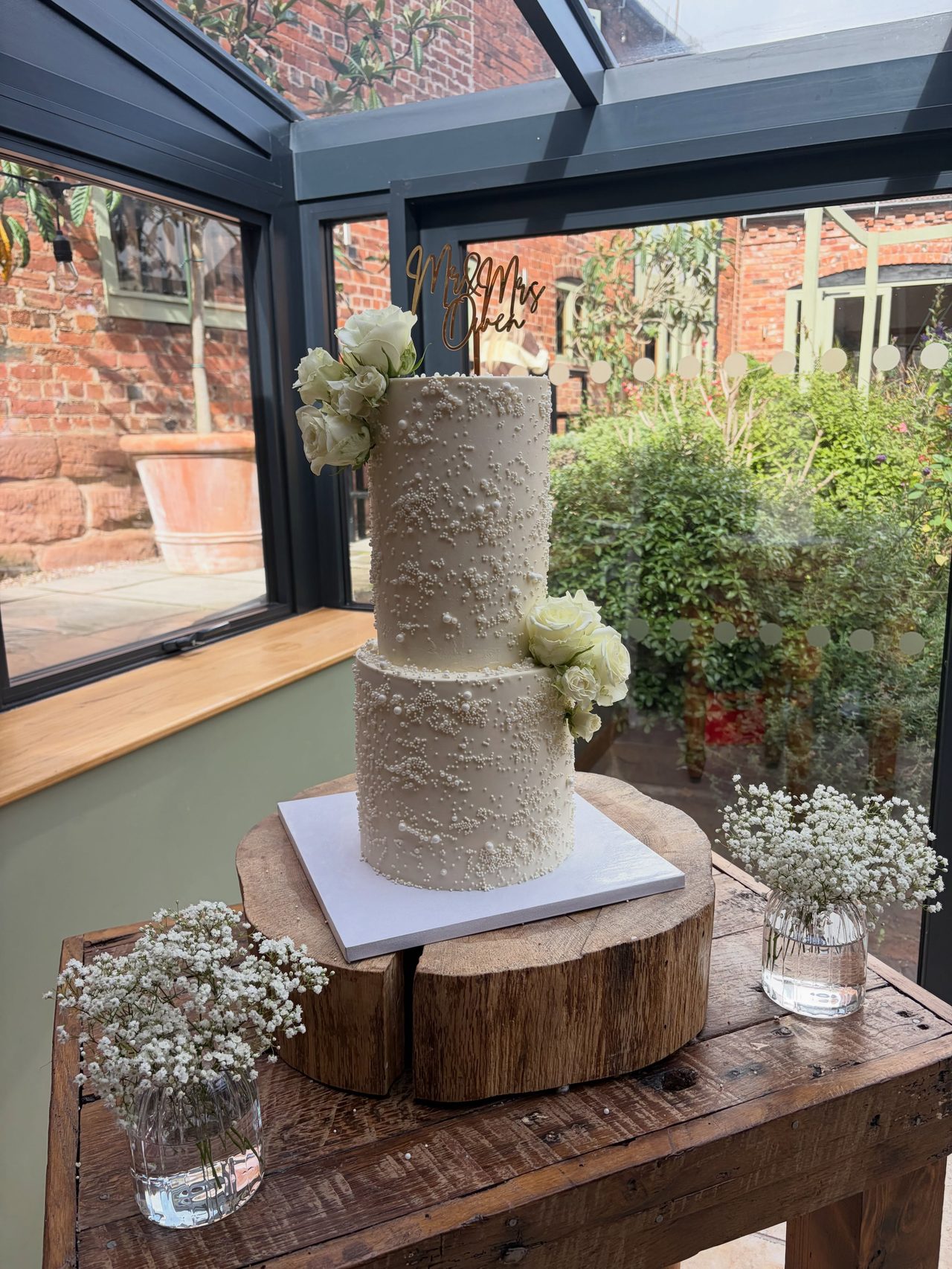 White wedding cake with fresh roses by The Bakehouse